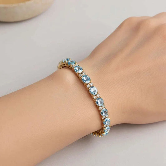 Gorgeous womens bracelet with oval sky blue topaz and round diamonds in 18K yellow gold plated sterling silver