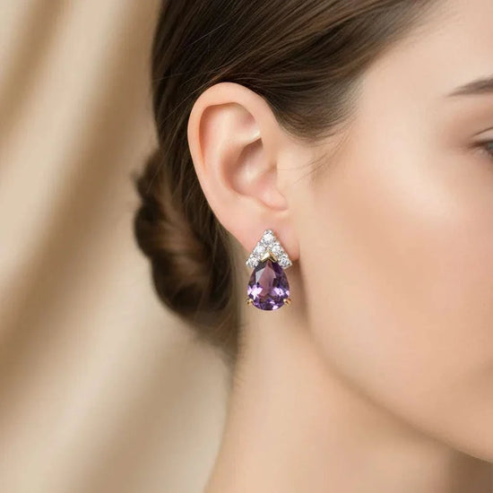Close-up of woman's ear wearing 18K yellow gold plated sterling silver earrings with pear-cut amethyst and round-cut diamond accents