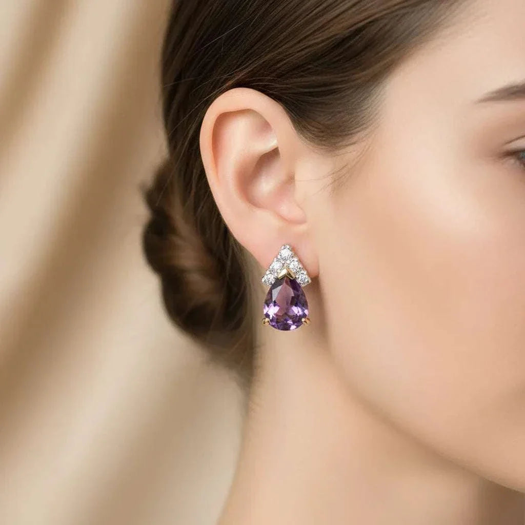 Close-up of woman's ear wearing 18K yellow gold plated sterling silver earrings with pear-cut amethyst and round-cut diamond accents