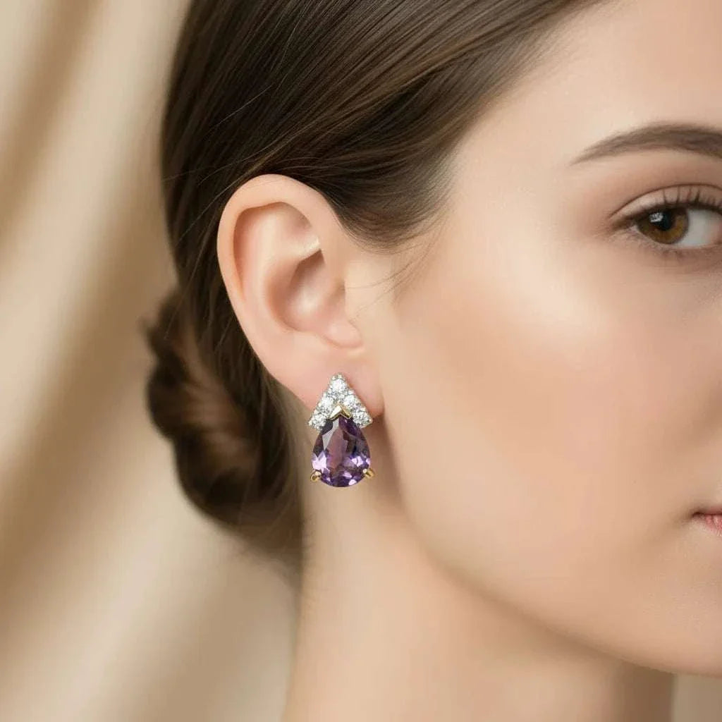 Close-up of woman wearing 18K yellow gold plated sterling silver earrings with pear-cut purple amethyst and diamond accents