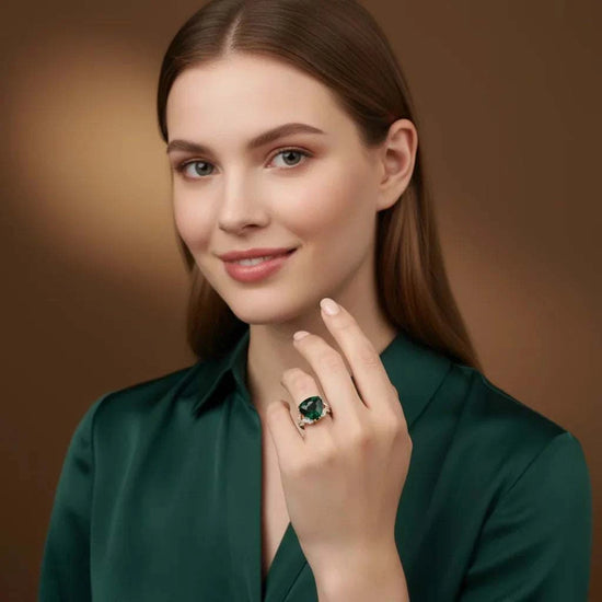 Woman wearing 14K white gold over silver emerald and diamond ring with 6.85 CTW trillion-cut emerald