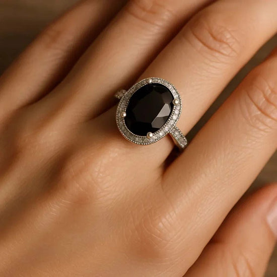 Women’s 14K white gold over silver ring with oval black sapphire and diamond accents on finger