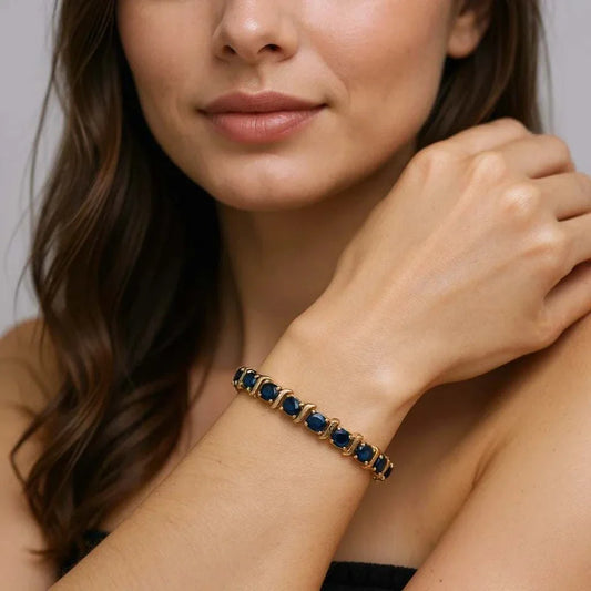 Women’s 18K yellow gold over sterling silver sapphire bracelet with oval blue sapphires on wrist