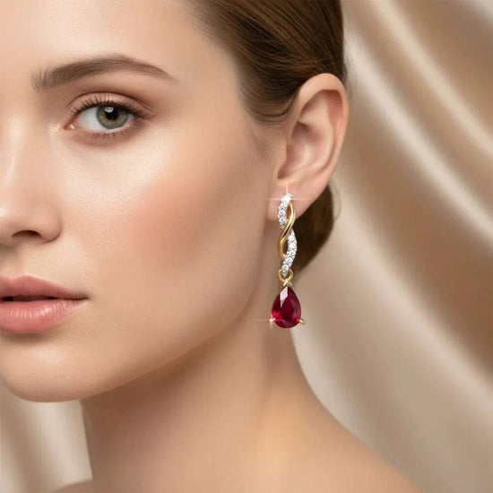 Elegant women's 14K yellow gold earrings with pear-cut ruby and round diamonds in sterling silver setting