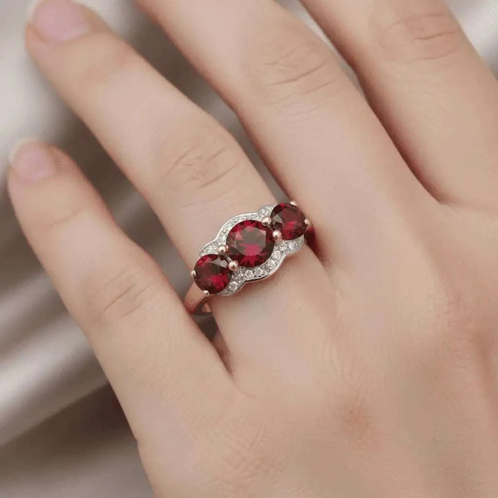 Women’s 14K yellow gold plated sterling silver ring with three round-cut garnets and diamond accents, size 7