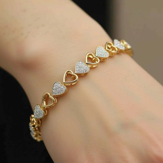 Women’s 14K yellow gold over sterling silver heart diamond bracelet 7-inch on wrist with alternating diamond and gold heart links