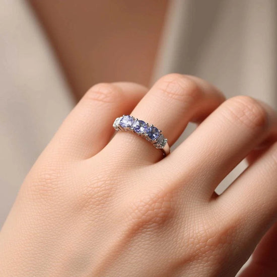 White gold rhodium plated sterling silver ring with violet tanzanite and diamond accents on hand
