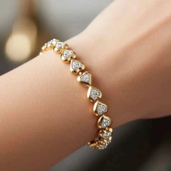 Women’s 18K yellow gold diamond heart bracelet with sterling silver base on wrist