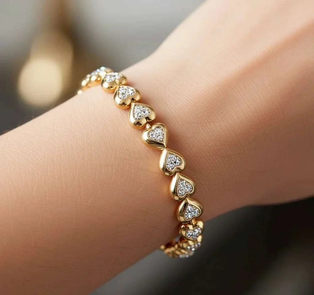 Women’s 18K yellow gold diamond heart bracelet with sterling silver base on wrist