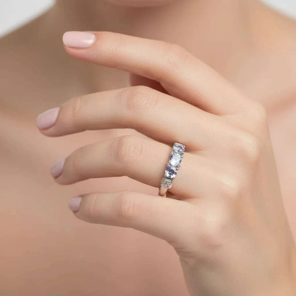 White gold rhodium plated sterling silver ring with violet tanzanite and diamond accents on woman's hand
