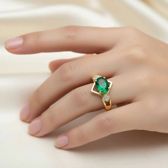 Women 14K yellow gold ring with oval green emerald and round diamonds on finger size 7