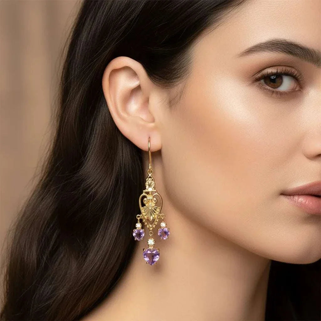 Victorian heart-inspired earrings in 18K gold plated sterling silver with amethyst and diamond accents worn on woman's ear