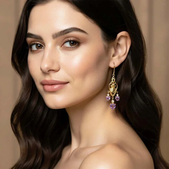Woman wearing Victorian heart-inspired earrings with gold plating and amethyst gemstones
