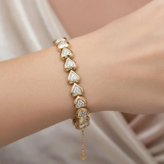 Women’s 18K yellow gold diamond heart bracelet with sterling silver accents on wrist