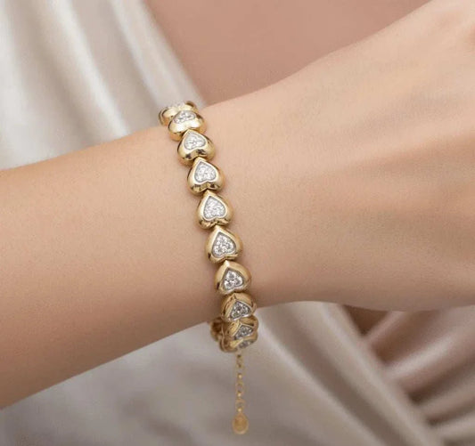 Women’s 18K yellow gold diamond heart bracelet with sterling silver accents on wrist